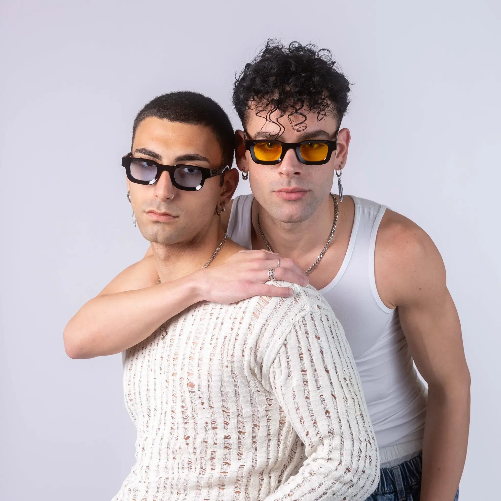 Two models wearing Exposure Sunglasses polarized sunglasses with black frames and tinted lenses, posing against a white background.