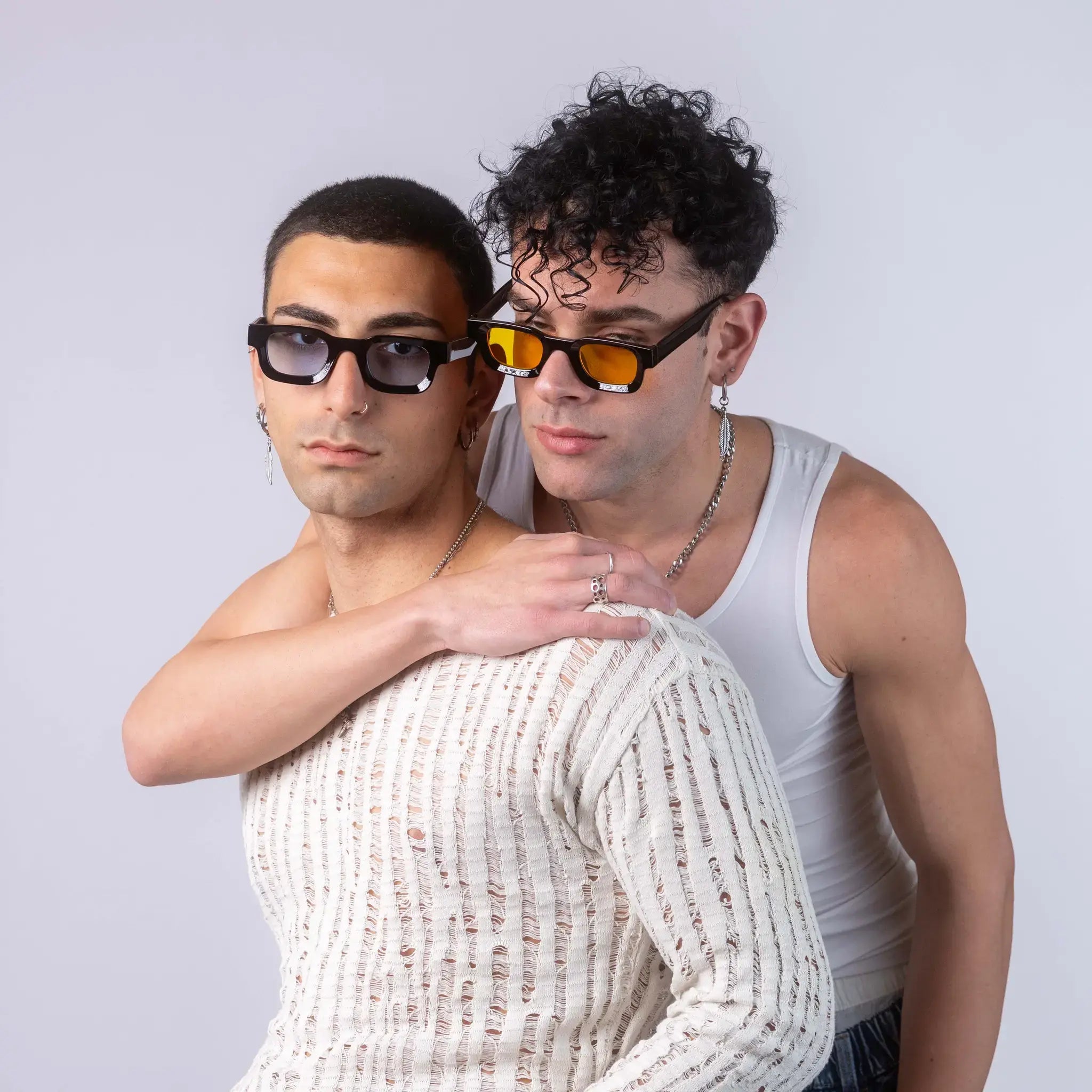 Two models wearing Exposure Sunglasses polarized sunglasses with black frames and tinted lenses, posing against a white background.