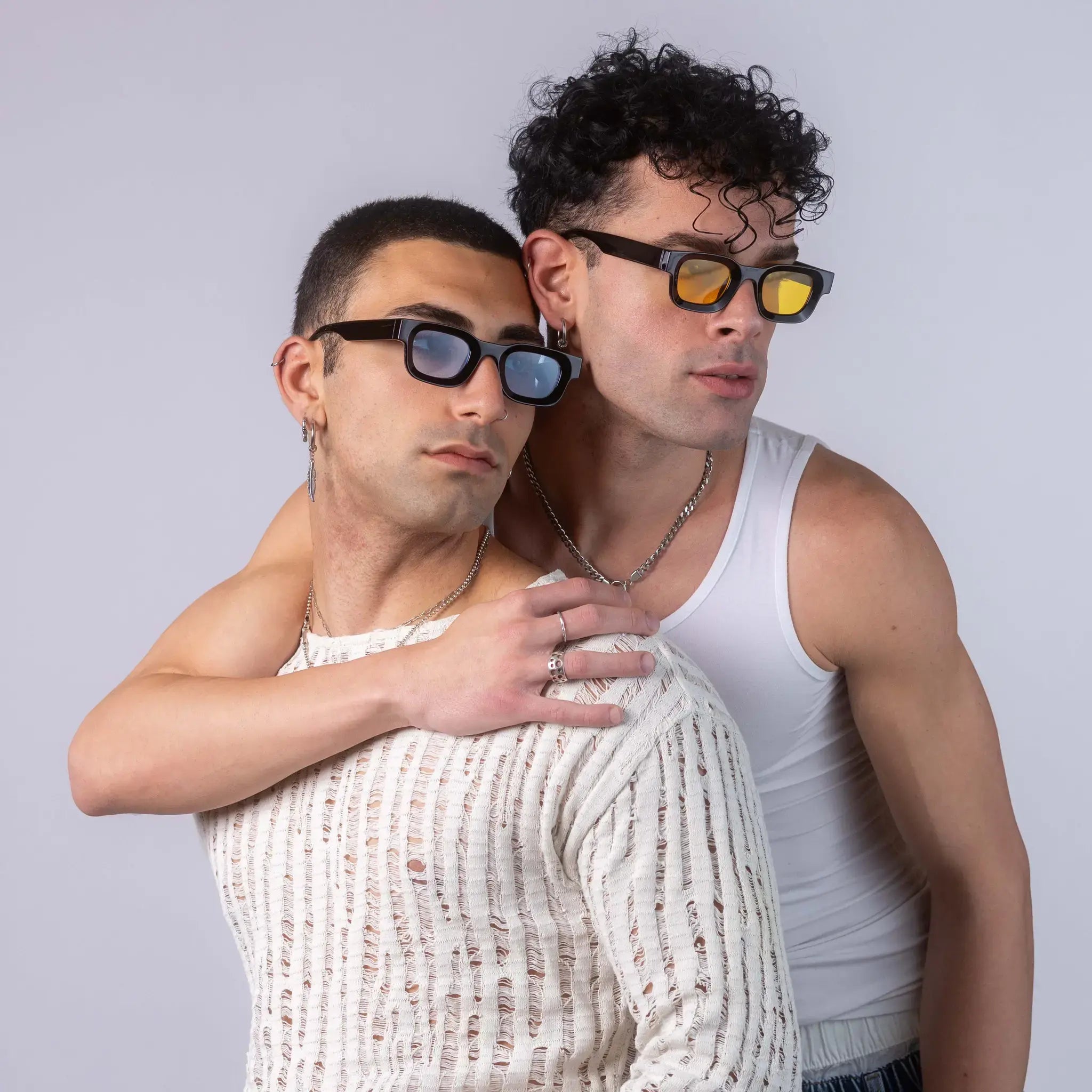 Two models wearing Exposure Sunglasses polarized sunglasses with black frames and tinted lenses, posing against a white background.