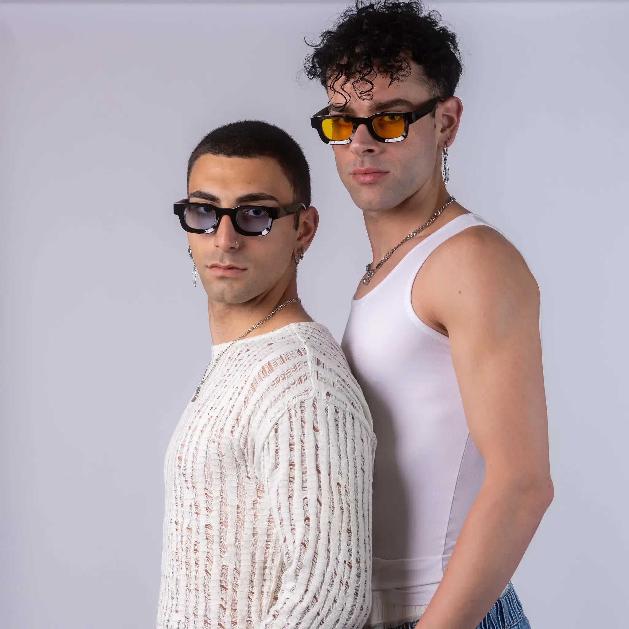 Two models wearing Exposure Sunglasses polarized sunglasses with black frames and tinted lenses, posing against a white background.