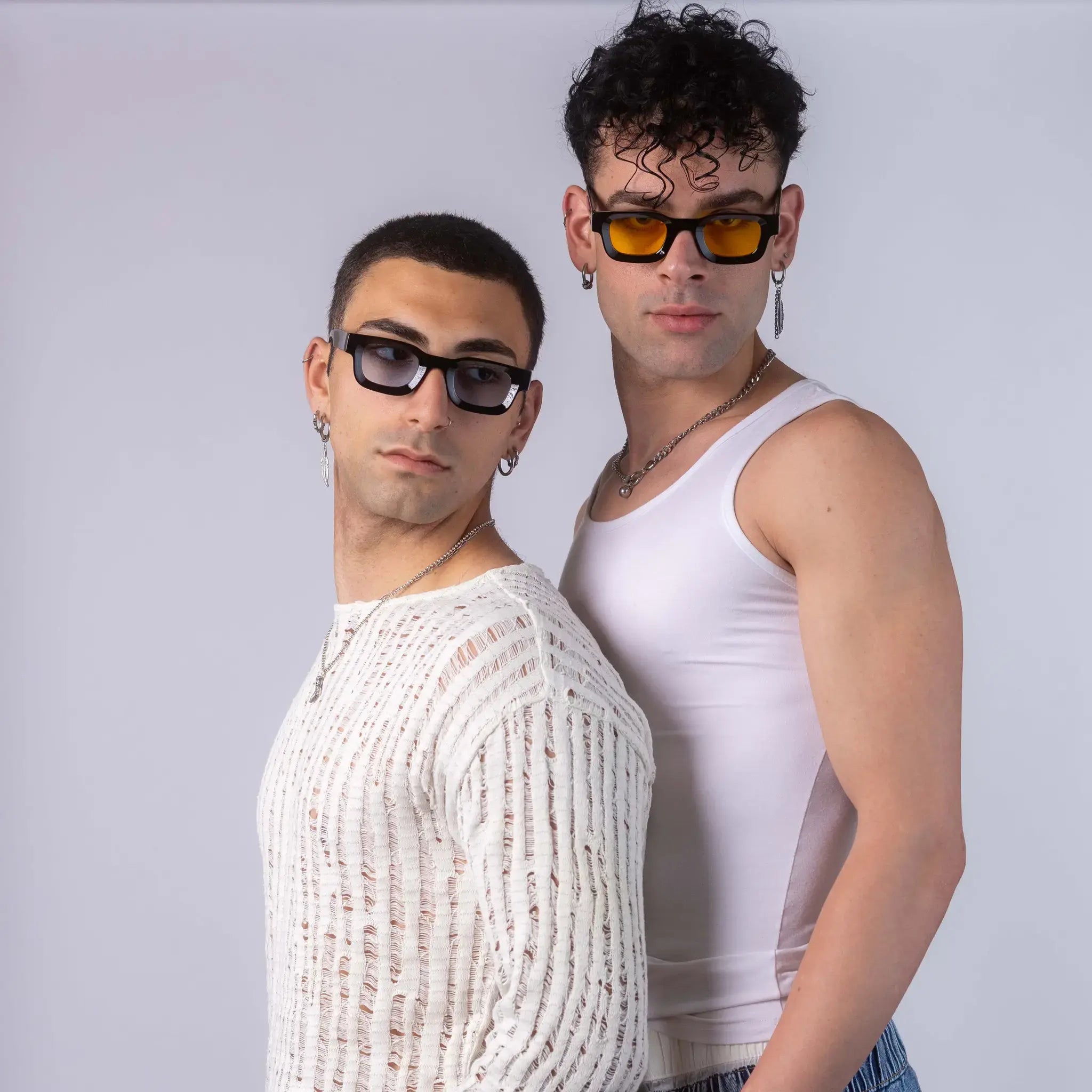 Two models wearing Exposure Sunglasses polarized sunglasses with black frames and tinted lenses, posing against a white background.