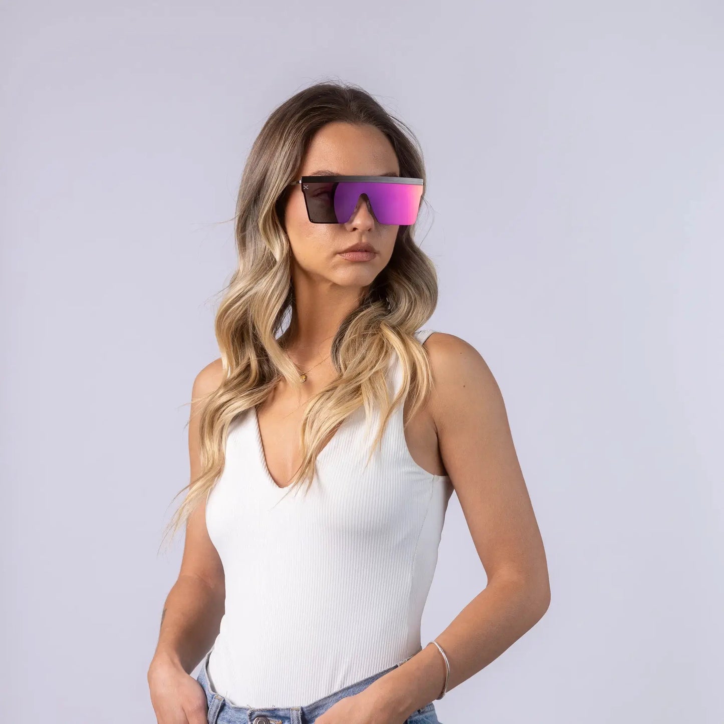 Γυαλιά ηλίου Jackie (μάσκα) της Exposure Sunglasses με προστασία UV400 με ασημί σκελετό και μωβ φακό φορεμένα από μοντέλο.