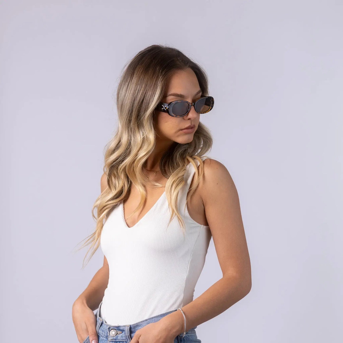 Οβάλ Γυαλιά ηλίου Vene από την Exposure Sunglasses με προστασία UV400 με καφέ σκελετό και μαύρο φακό. Φορεμένα από μοντέλο.